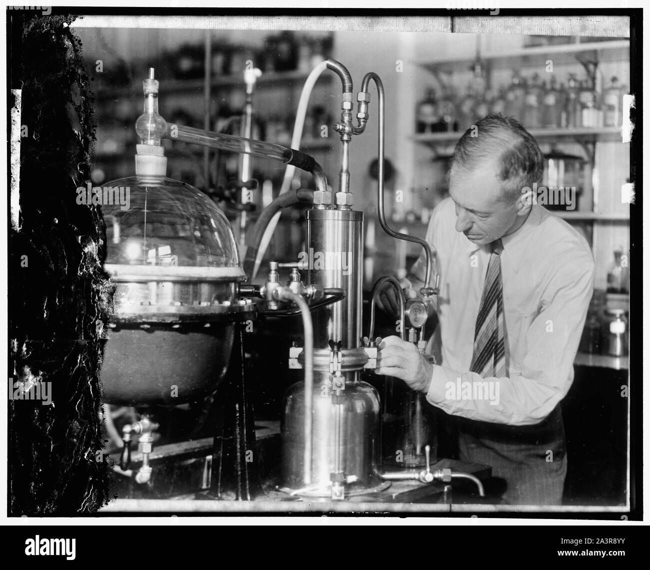 Studium Warum Früchte, die Art und Weise probieren. E.K. Nelson von der Abteilung für Landwirtschaft wird gezeigt, dass Tests mit einem Apparat, der die Abteilung aus Deutschland zum Zweck des Studiums der ätherischen Ölen oder Geschmack - die Inhalte von Obst und Gemüse bei der Einfuhr. Derzeit Chemiker die ätherischen Öle von nur ein paar Früchte, wie einige der Zitrusfrüchte Gruppe kennen. Der Apparat ist ein Vakuum destillieren die Destillation von Flüssigkeiten bei Temperaturen weit unter den üblichen Genehmigungen durch die Reduzierung der Druck, 1/10/31. Stockfoto