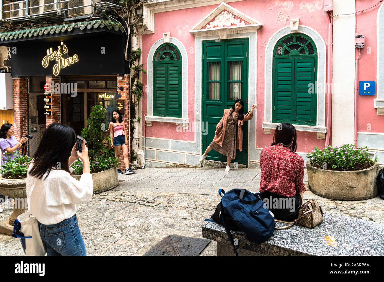 Macau, China - 15 Oktober 2018: asiatische Frau touristische posinging für Foto vor der berühmten bunte Fassade in der traversa da paixao, oder Liebe lan Stockfoto