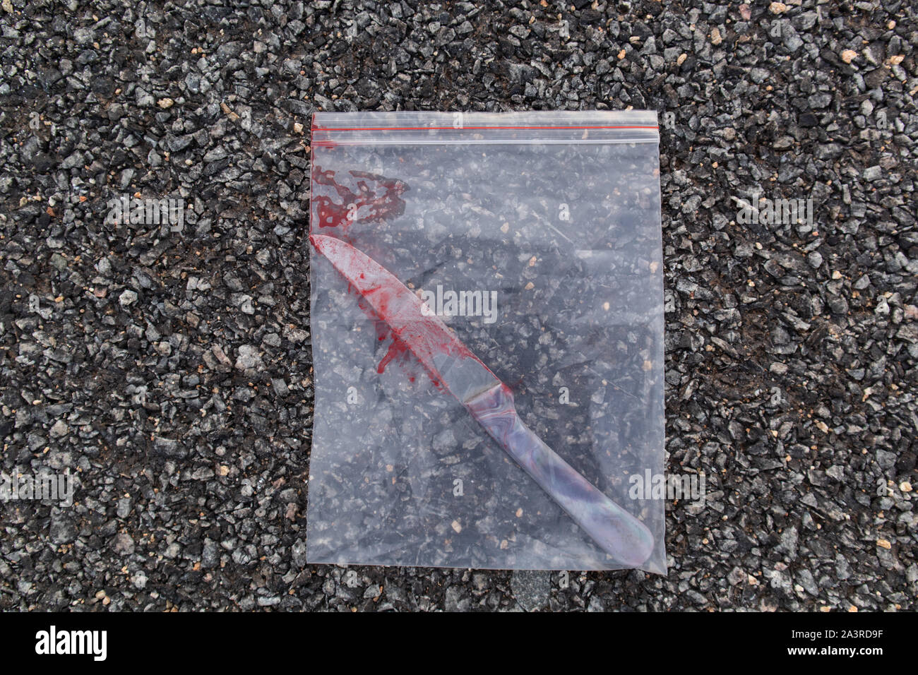 Blutiges Messer in Kunststoff oder Beweis Tasche auf der Straße. Stockfoto