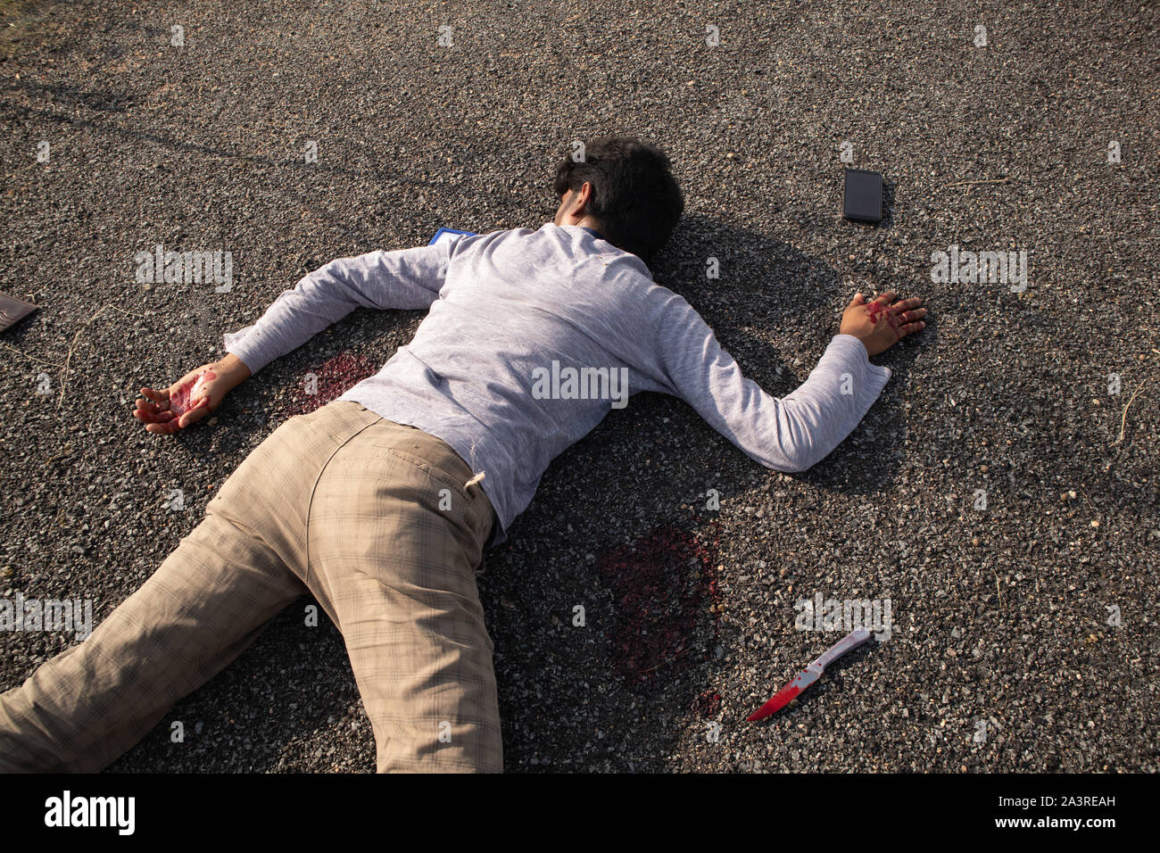 Konzept der Kriminalität oder Mordszene, Nahaufnahme der Toten Opfer ermordet mit Messer am Straßenrand Stockfoto
