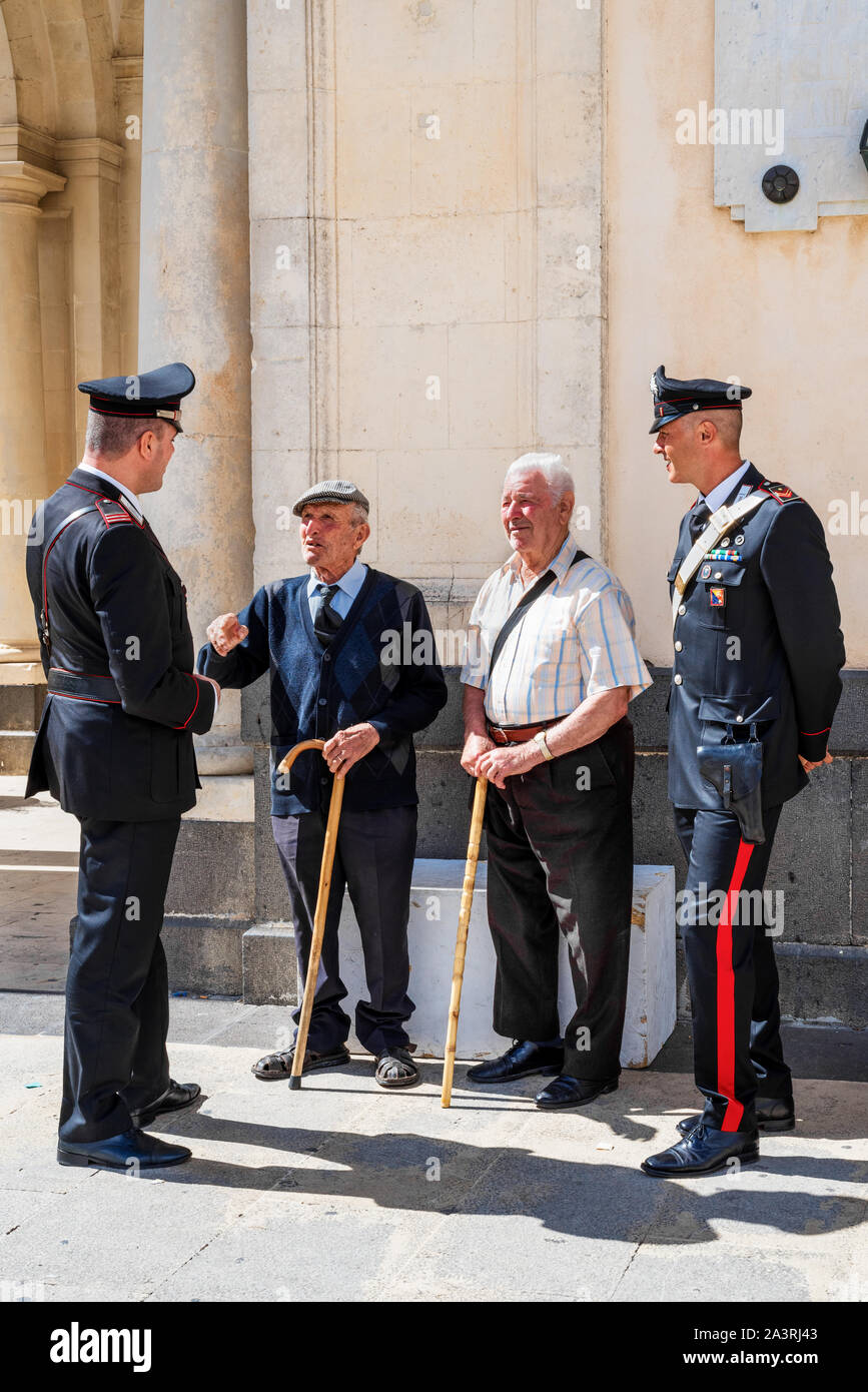 Palazzolo Acreide Syrakus/Sizilien/Italien - 04 Oktober 2019: Carabinieri mit zwei ältere Menschen in der Palazzolo Acreide square diskutieren Stockfoto