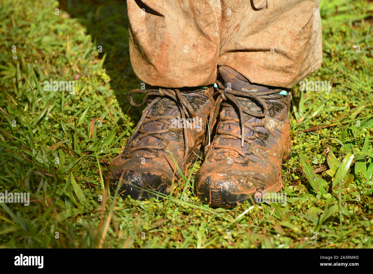 Eine Nahaufnahme von matschigen Wanderschuhe und schmutzige Hosen nach einem erlebnisreichen Spaziergang im Regenwald. Madagaskar Stockfoto