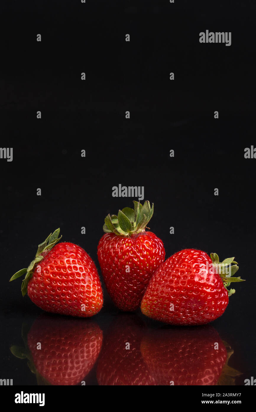 Rote Erdbeere auf einem schwarzen Hintergrund mit Freistellungspfaden. Stockfoto