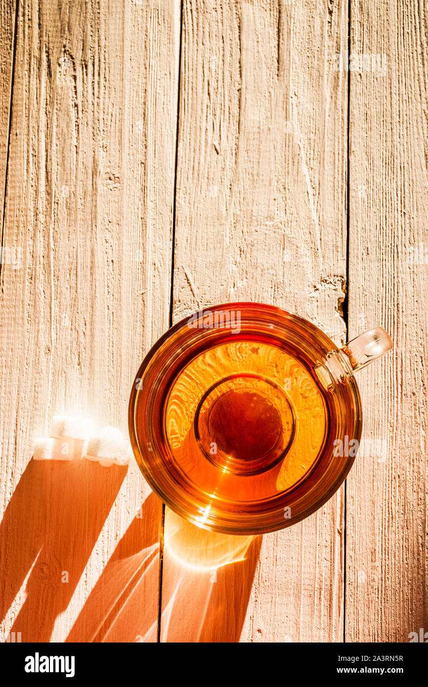 Bild von Glas Tasse mit Tee und Zucker auf Holz- Oberfläche. Stockfoto