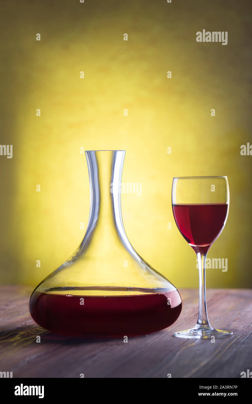 Ölabscheider mit Rotwein und Glas auf Stuck Hintergrund mit Freistellungspfad Stockfoto