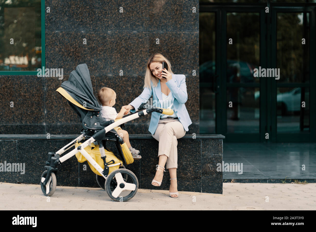 Porträt eines erfolgreichen Business Frau im blauen Anzug mit Baby. Die Frau am Telefon zu sprechen Stockfoto