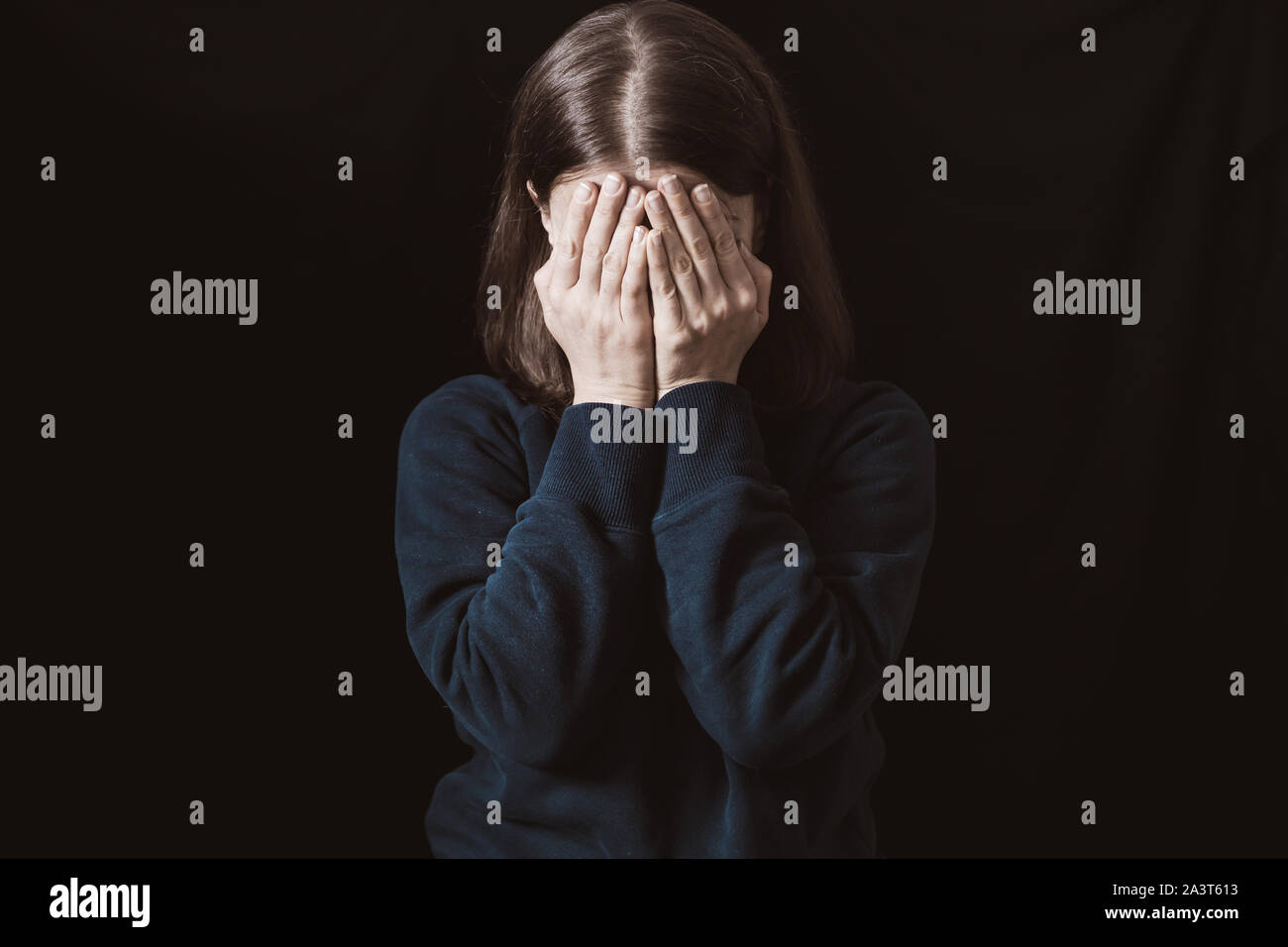 Gewalt. Weinende Frau auf schwarzem Hintergrund. Stockfoto
