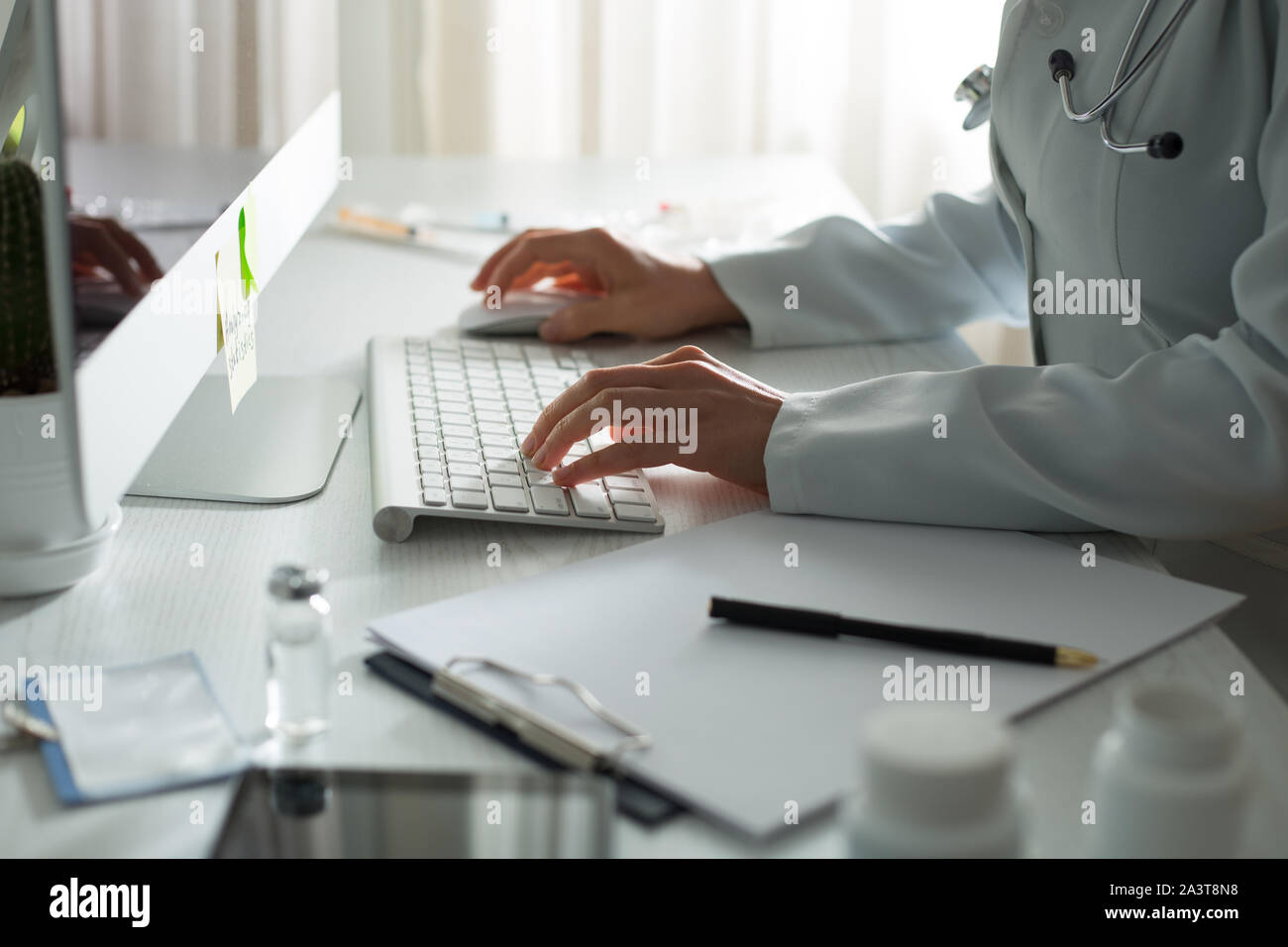 Frau Doktor schreibt einen medizinischen Bericht im Büro der Klinik. Stockfoto