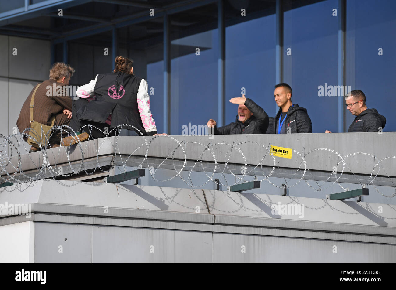 Die verhandlungsführer versuchen Demonstranten vom Dach des City Airport, London zu überreden, während ein Aussterben Rebellion Klimawandel protestieren. Stockfoto