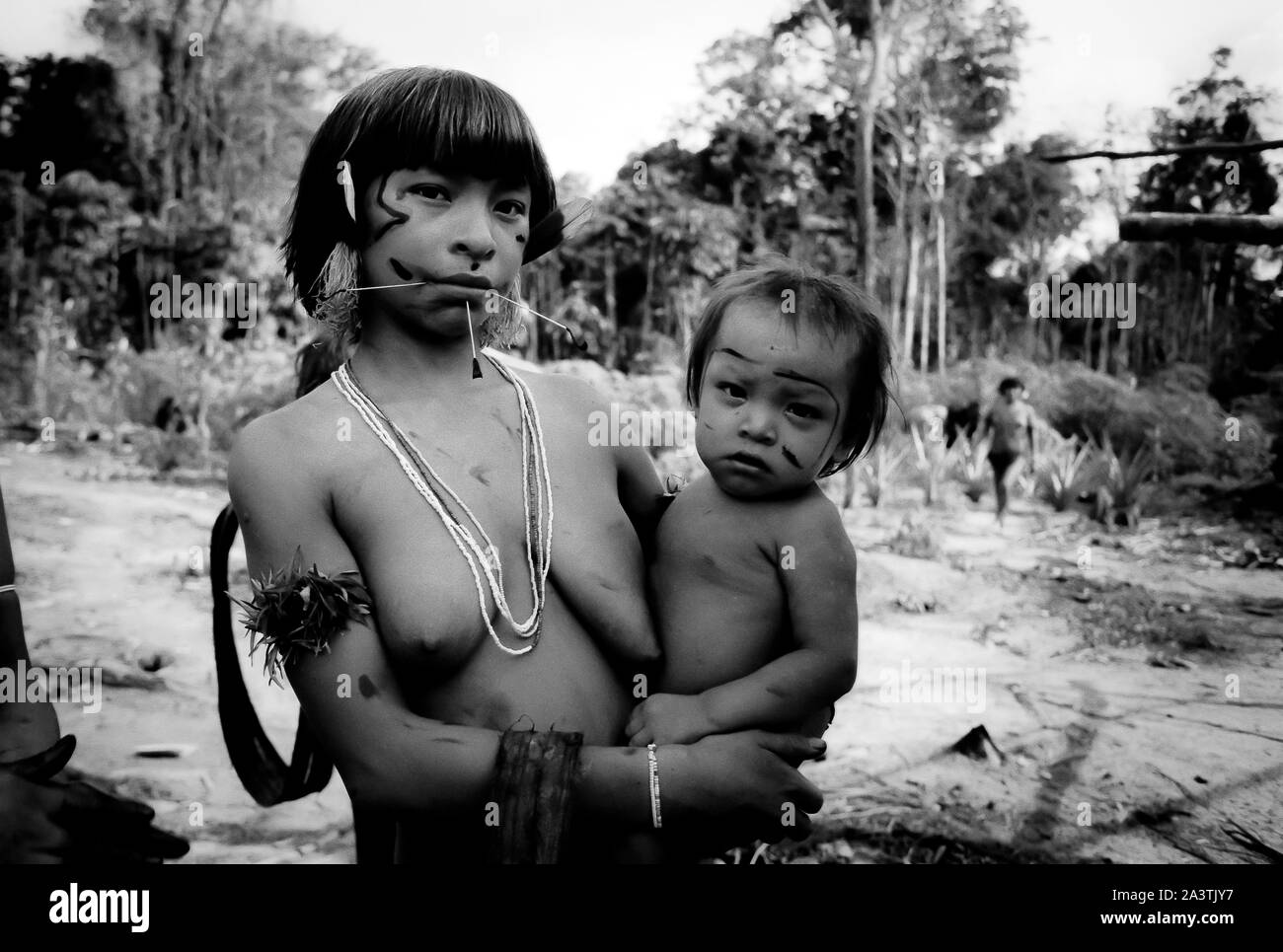 Brasilien, Amazonien, Roraima: Eine junge Yanomami-Frau mit ihrem Sohn in den Armen. Stockfoto