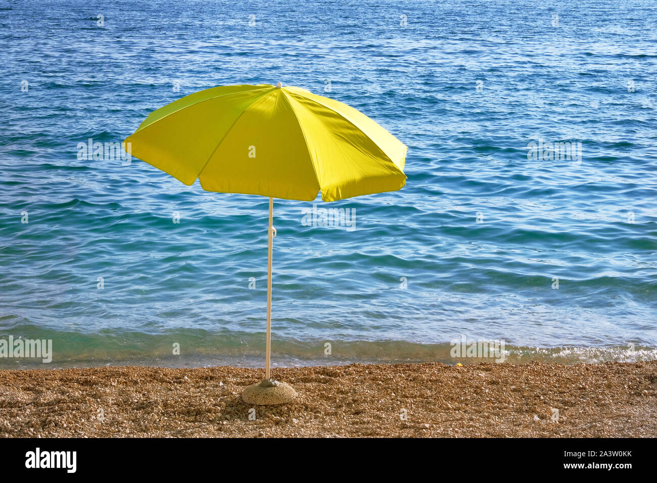 Yellow Umbrella auf Sommer Strand. Meer Strand mit Sonnenschirm warten auf Touristen. Happy Sommer Ferien Konzept. Stockfoto