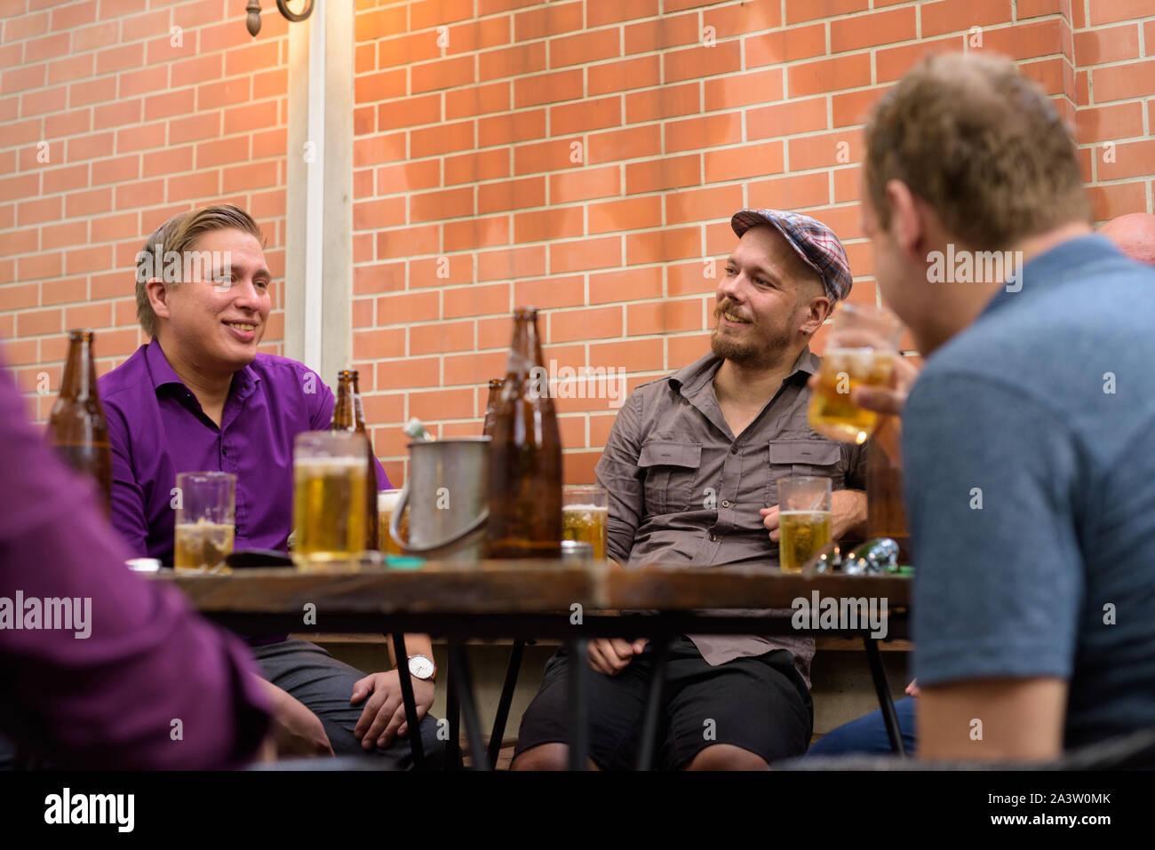 Gruppe der glückliche Männer draußen sitzen und Bier trinken. Stockfoto