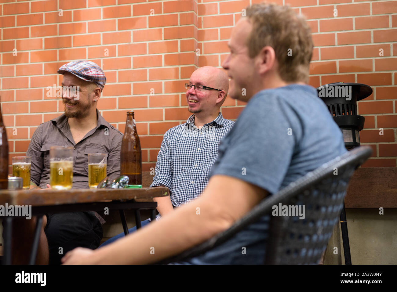 Gruppe der glückliche Männer draußen sitzen und Bier trinken. Stockfoto