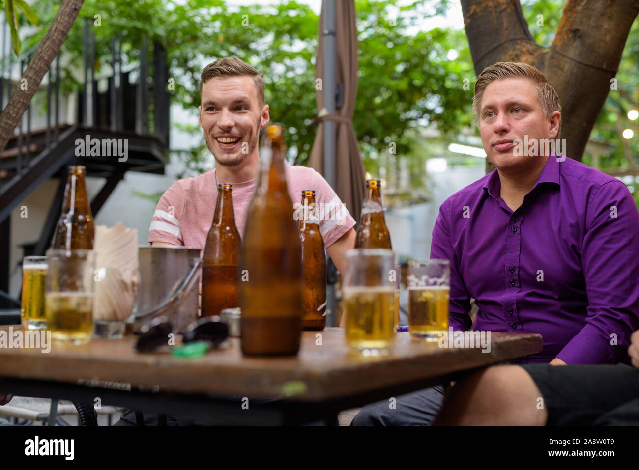 Männer sprechen und lachen, während draußen Bier trinken. Stockfoto