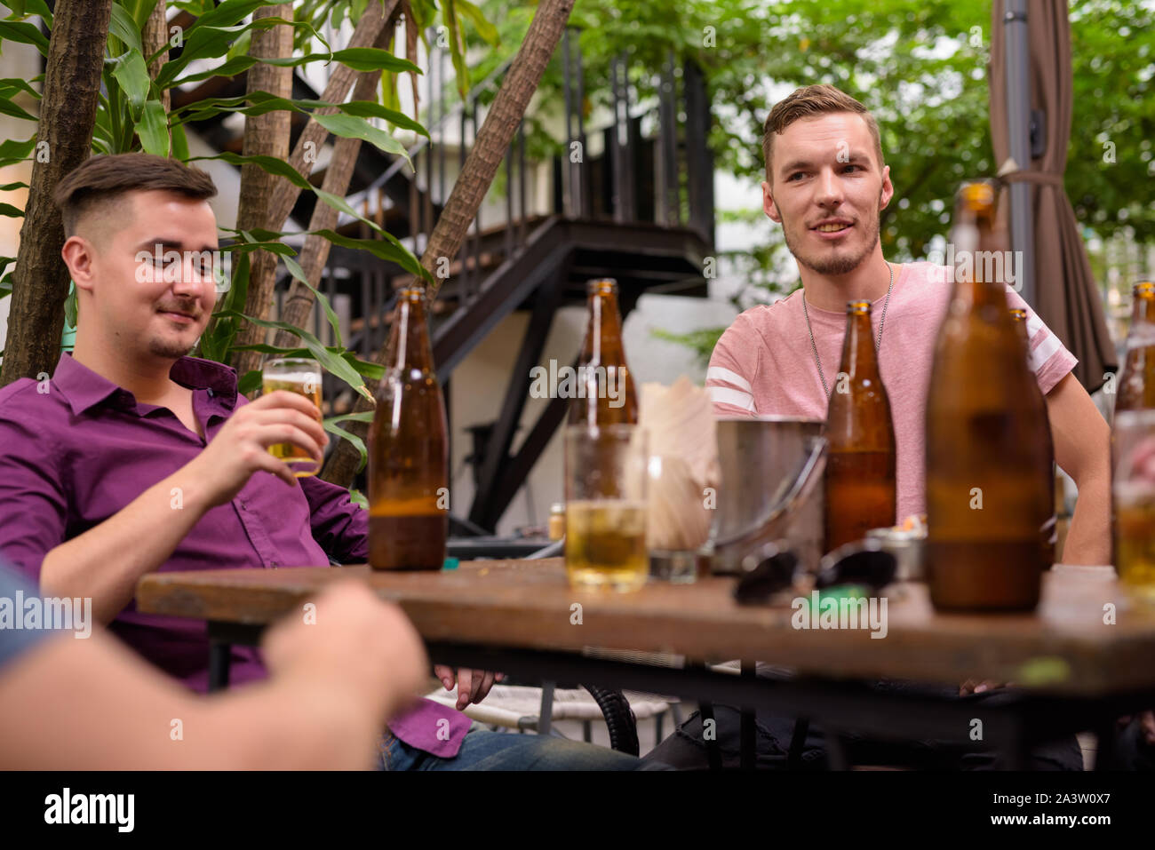 Glücklich lächelnd, während Männer trinken Bier im Freien Stockfoto