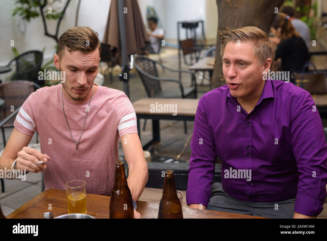 Mann rauchen Zigarette beim Trinken von Bier mit Freunden Stockfoto