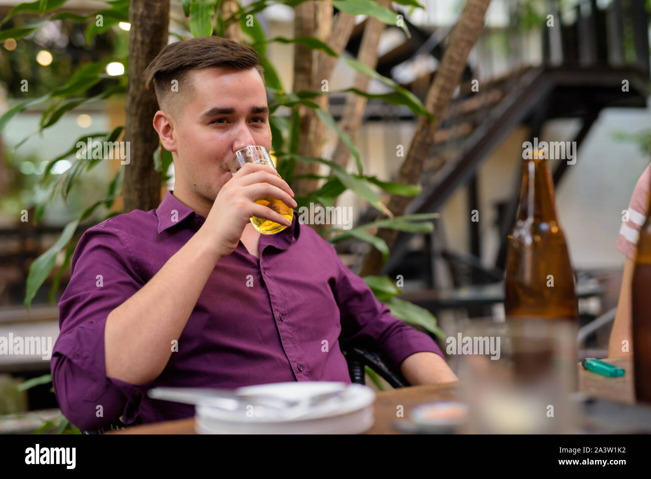Mann sitzen im Freien und trinken Bier aus Glas Stockfoto