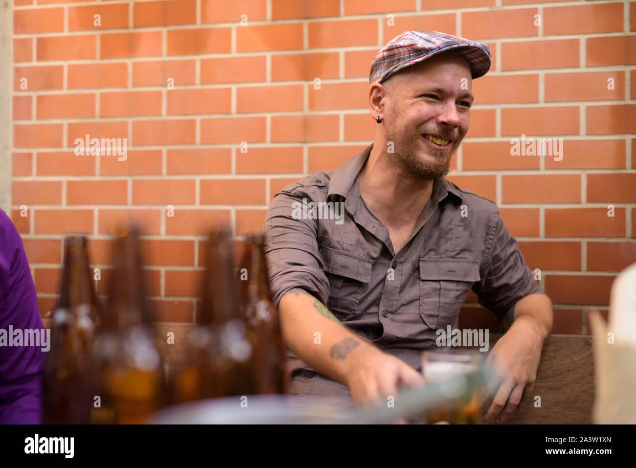Happy Hippie mann Lächeln und Lachen, während draußen Bier trinken. Stockfoto