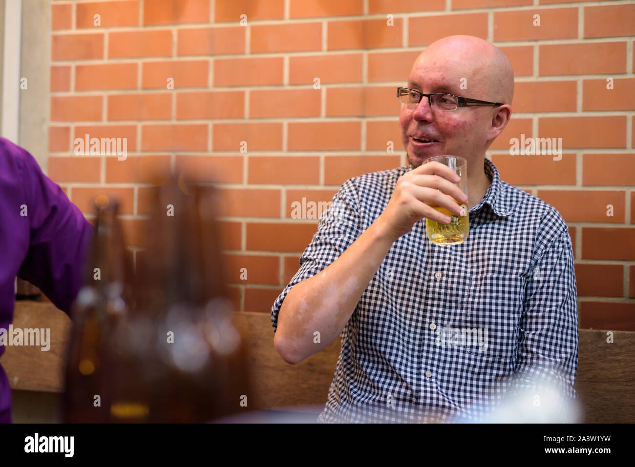 Happy glatzköpfige Mann draußen sitzen und Bier trinken. Stockfoto