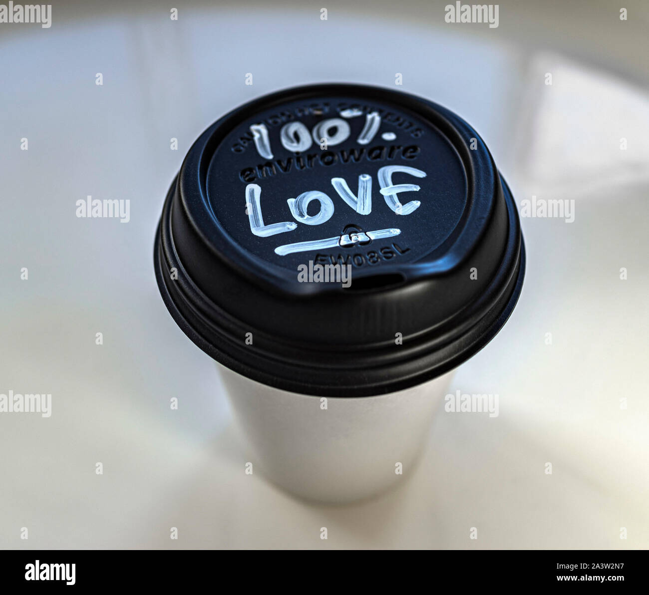 Einweg Kaffeebecher mit einer Hand schriftliche Nachricht von 100% Liebe. Sehr sauberes Bild. Stilisiert. Stockfoto