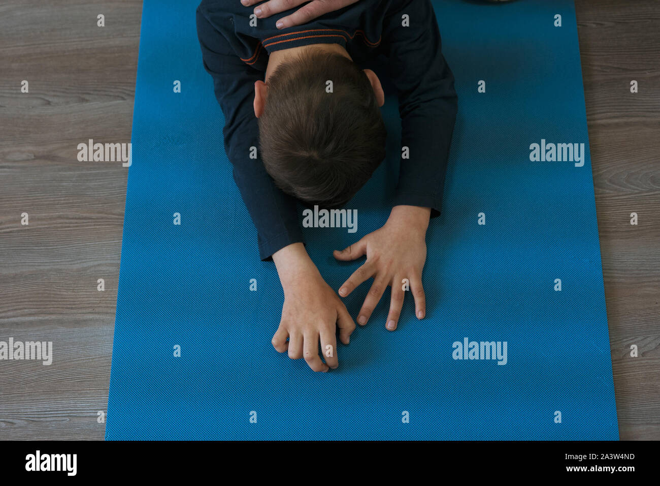 Kleine Junge ist in der Gymnastik auf eine Yogamatte, stehend auf Knien, ca. 5 Jahre alt. Stockfoto