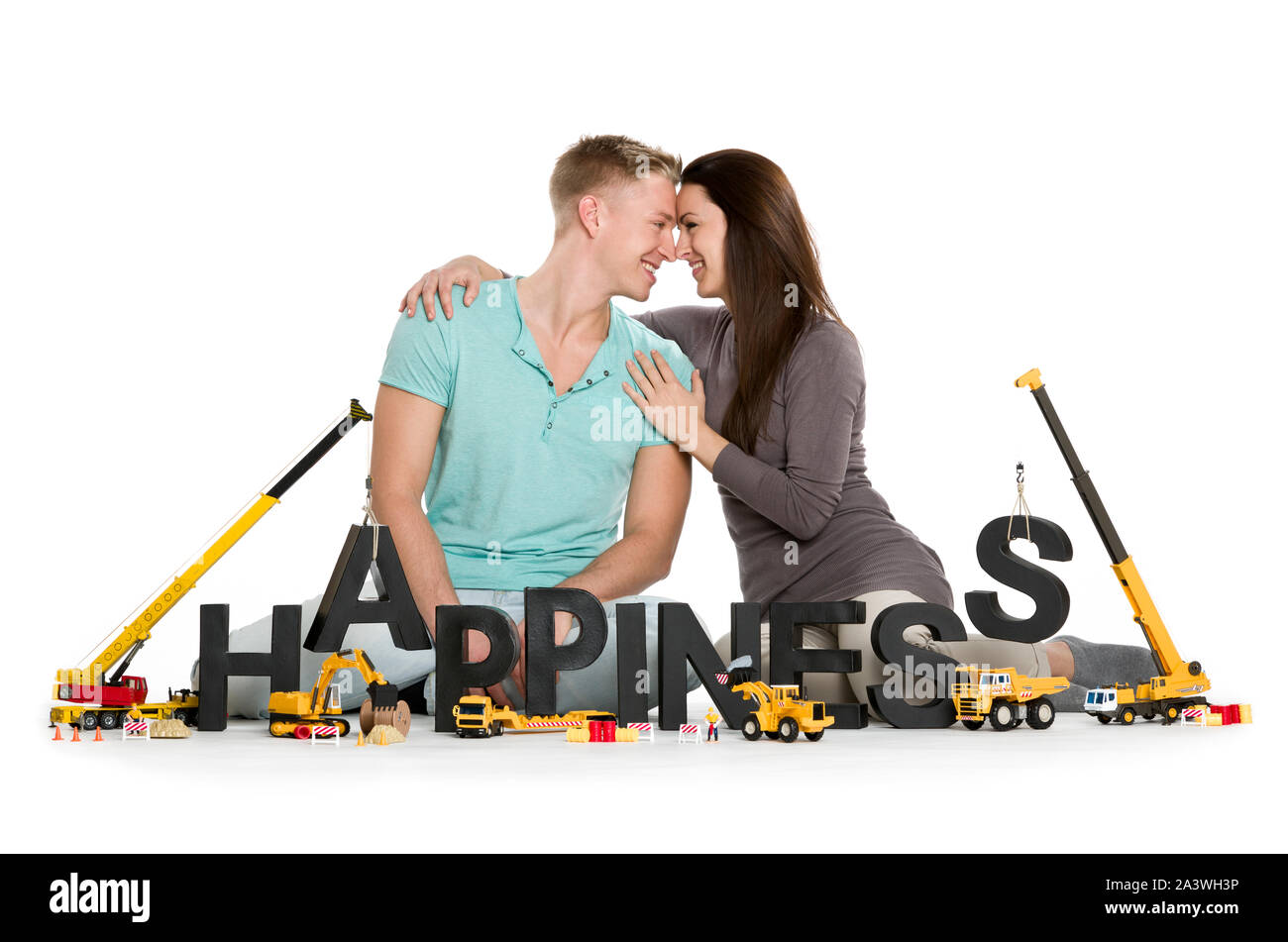 Glücklich lächelnde Frau und Mann Gebäude Glück - Wort. Stockfoto