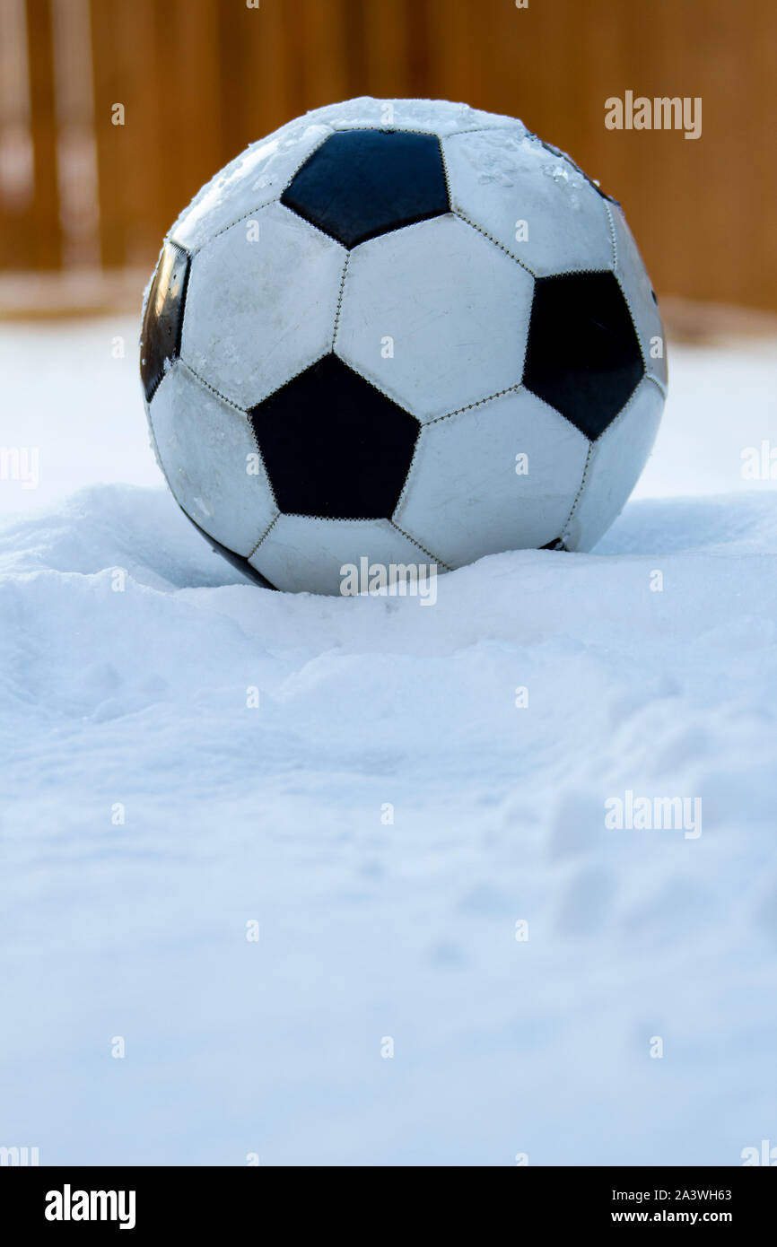 Fußball, Fußball auf Schnee mit einem hölzernen Hintergrund Stockfoto