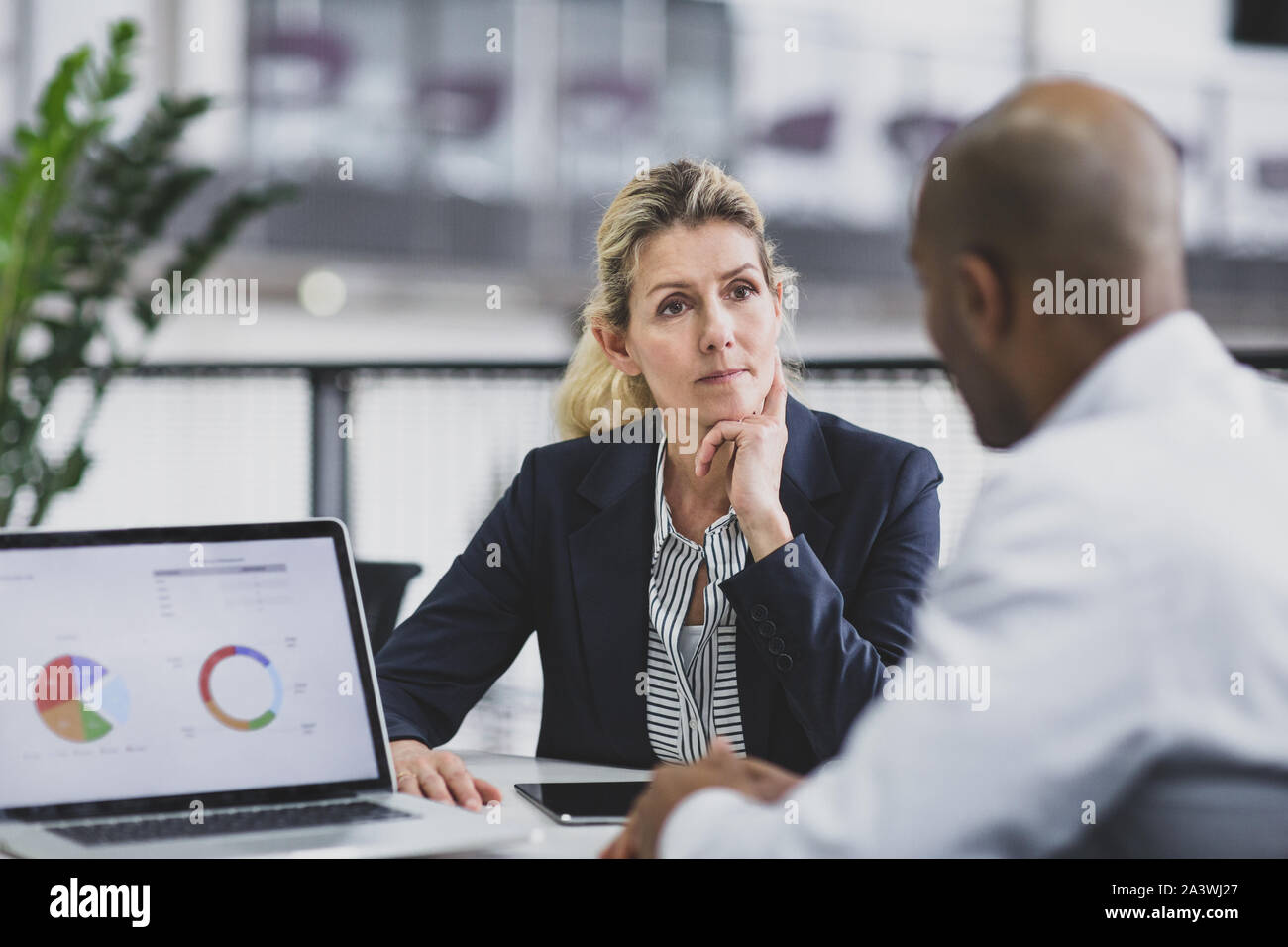 Ältere weibliche Führungskraft Hören zu einem Mitarbeiter in einer Besprechung Stockfoto