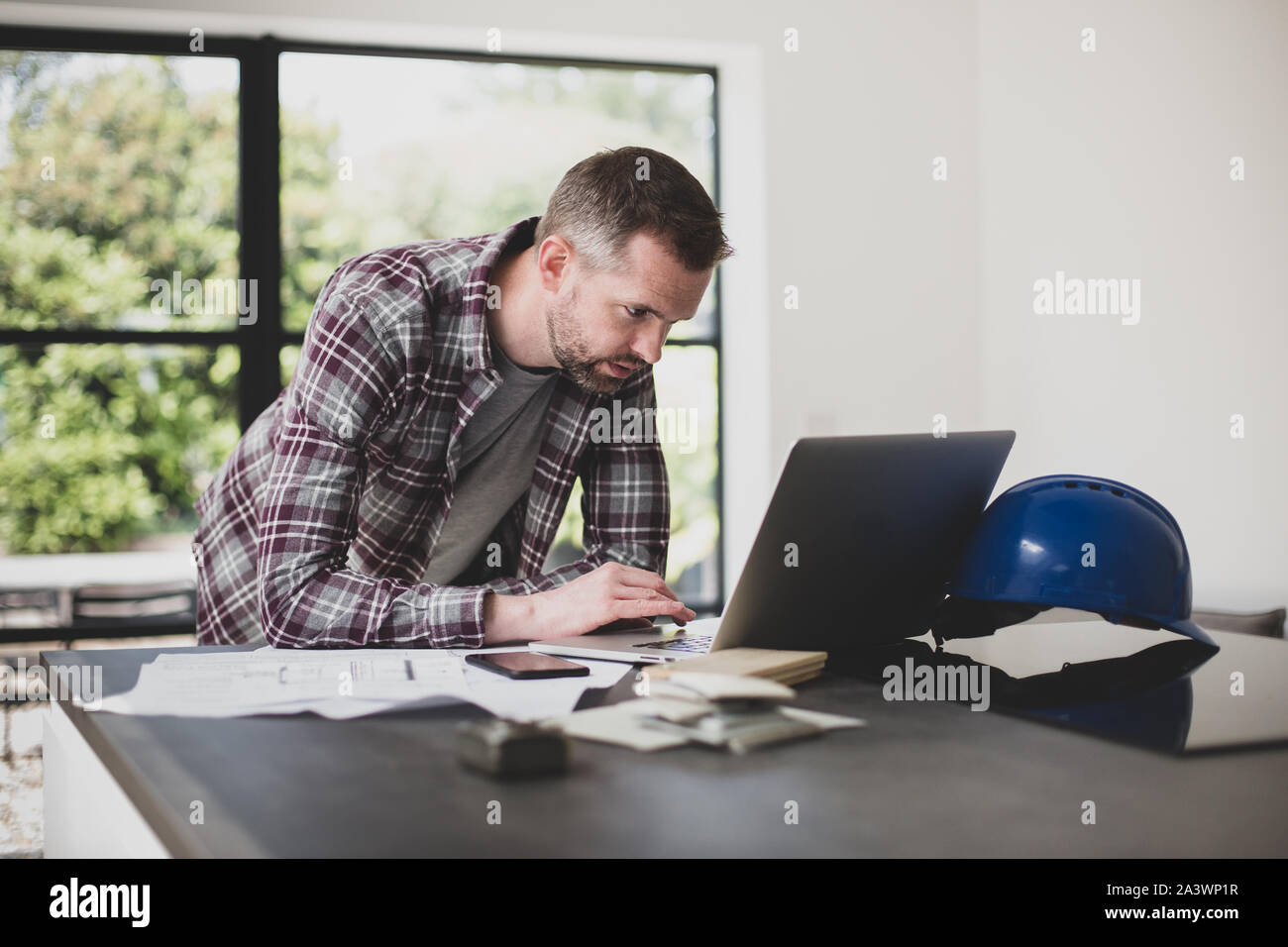 Auftragnehmer mit Laptop in Home Entwicklung Stockfoto