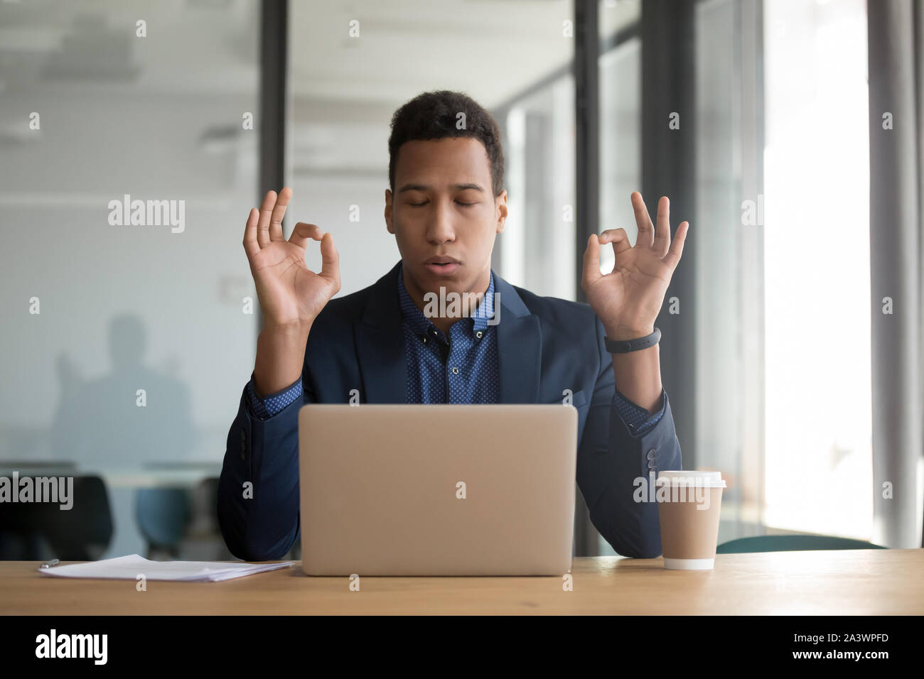 Ruhig achtsam schwarz Geschäftsmann in Anzug meditieren am Schreibtisch Stockfoto