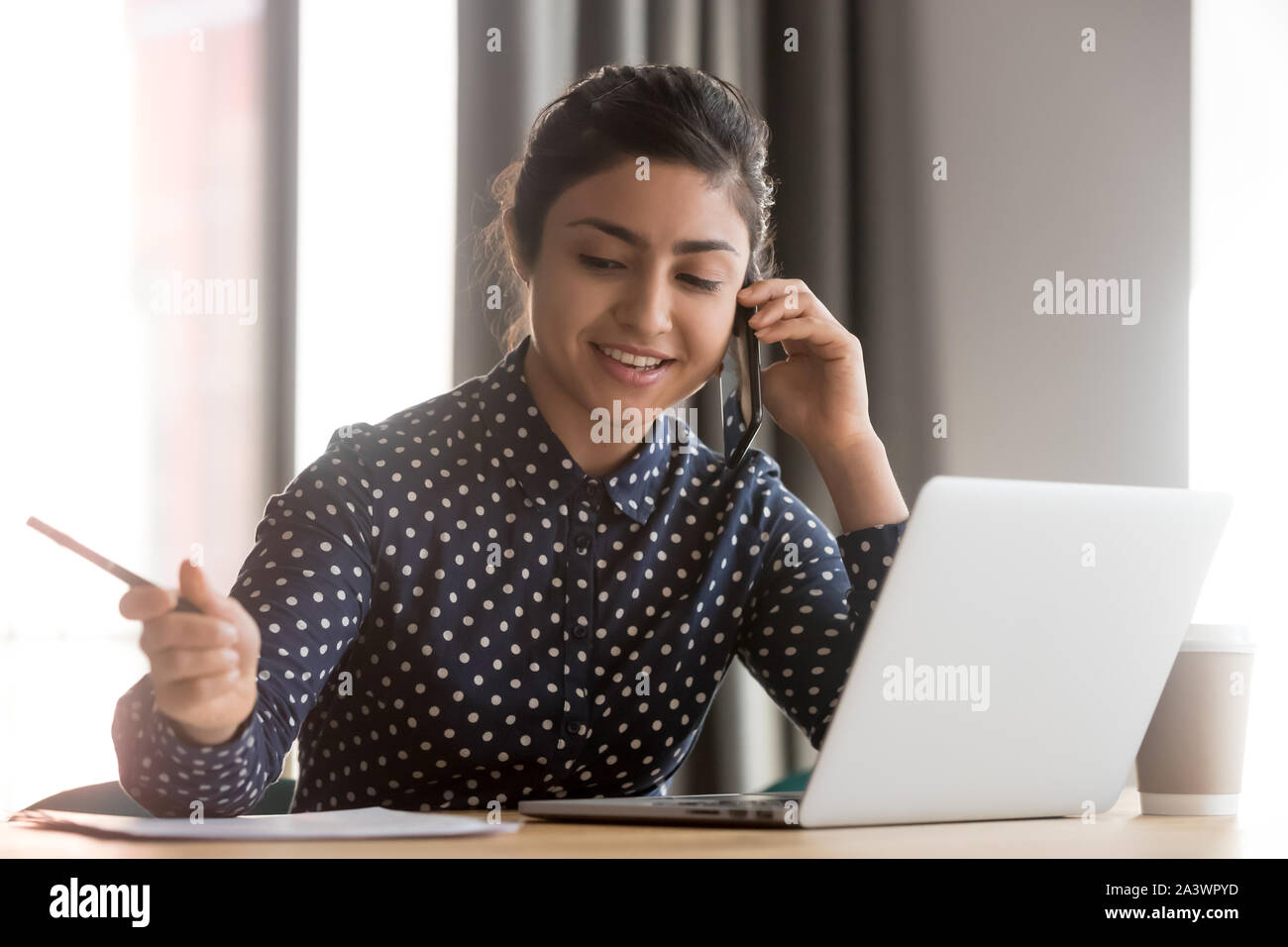 Lächelnd indischen Business woman Talk am Telefon Notizen schreiben Stockfoto
