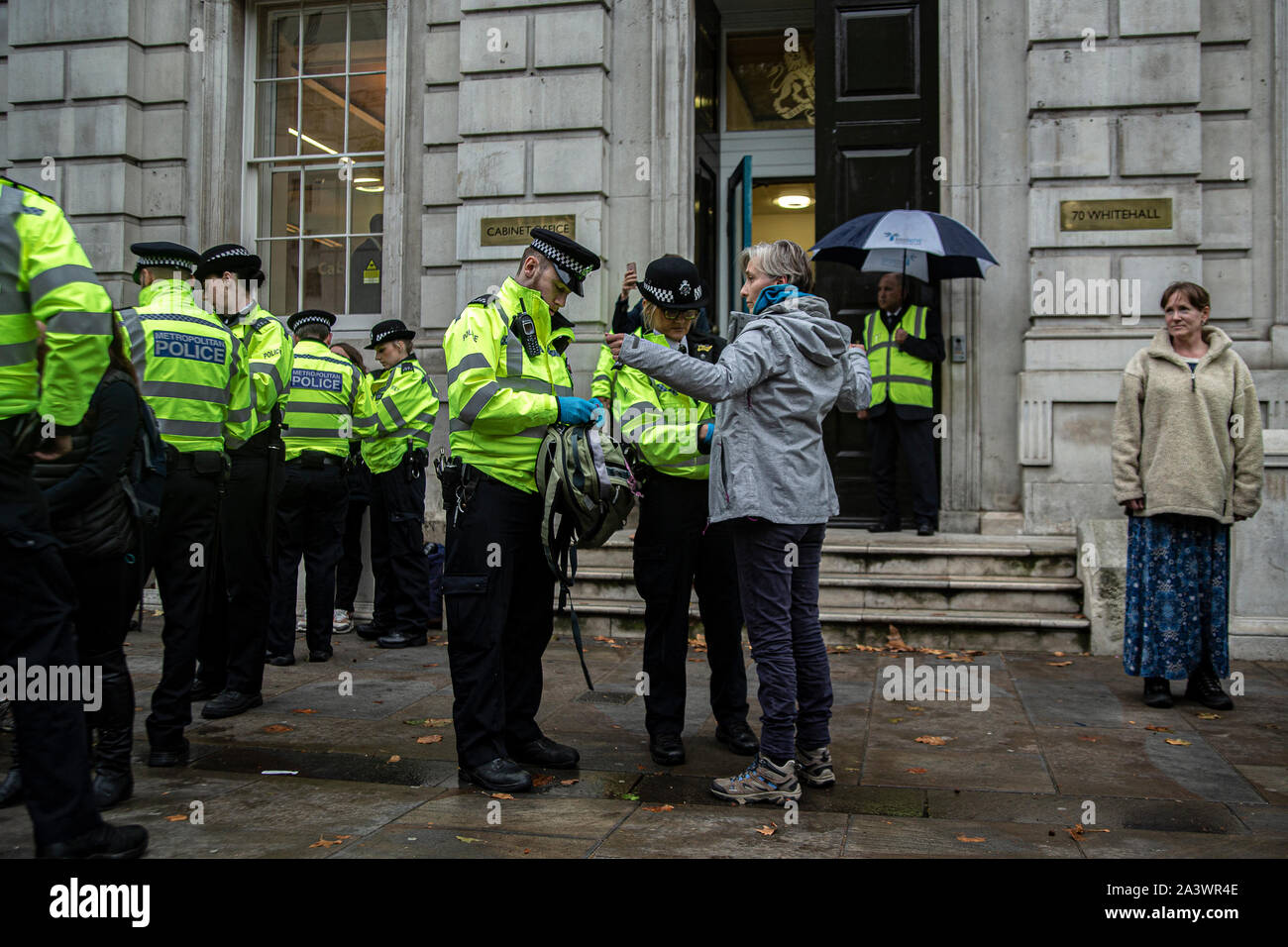 Eine Frau wird von der Polizei nach einer Sperrung der Straße in Whitehall festgenommen hinterfragt, Central London, am Aussterben Rebellion Proteste. Demonstranten auf die Straße im Zentrum von London nahm auf diese Woche und Nächste Woche die 'Klima Notfall" mit Blick auf die Planeten zu markieren. Stockfoto