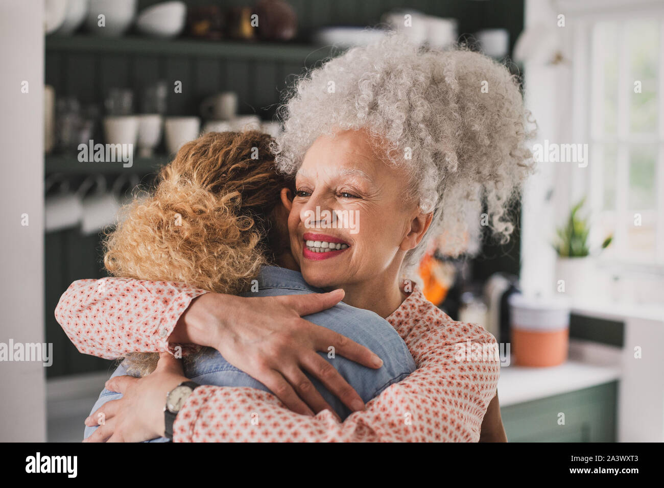 Ältere Erwachsene Frau umarmen Tochter Stockfoto