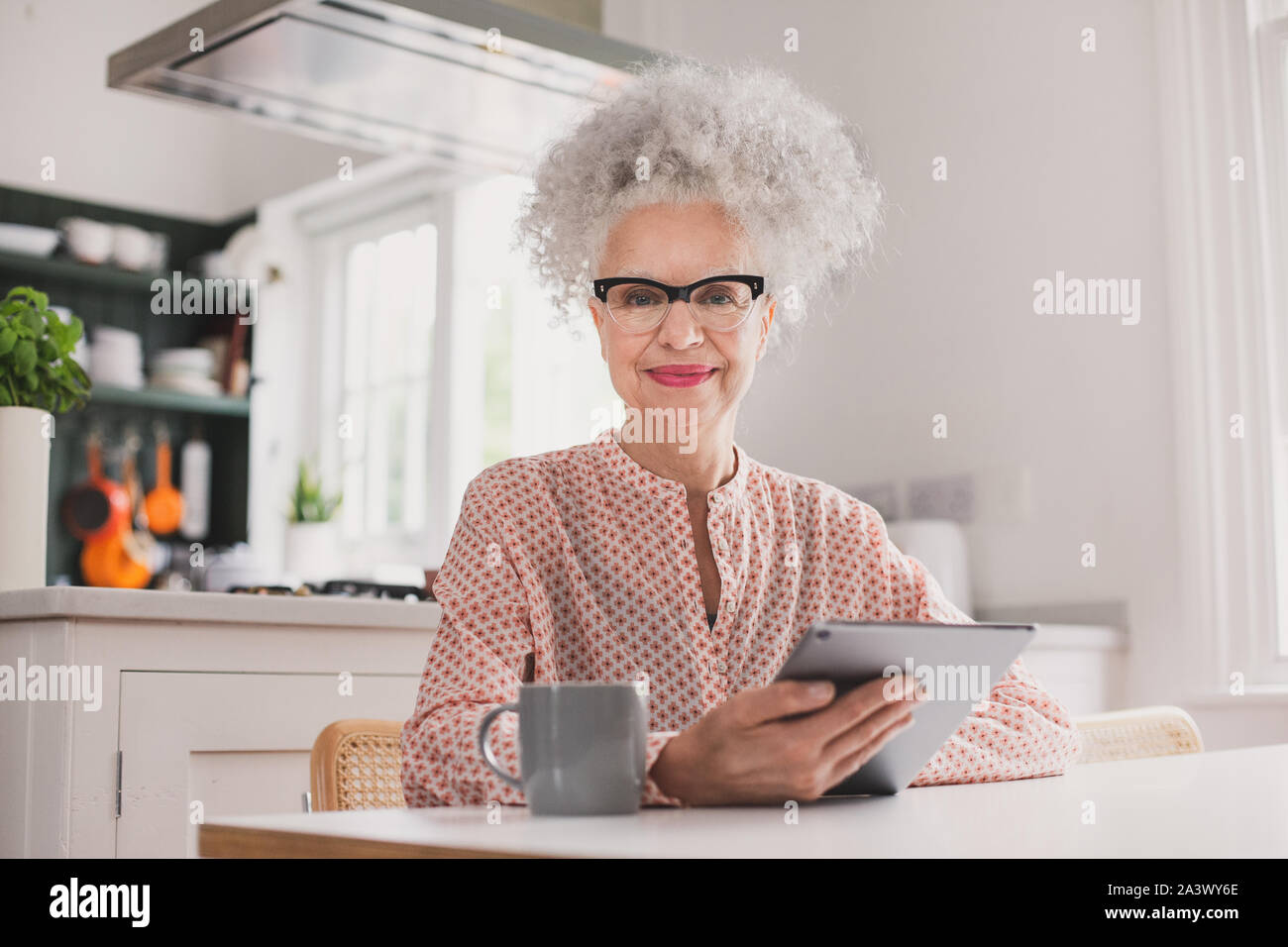 Portrait von älteren Erwachsenen weiblichen Blick auf digitale Tablette zu Hause Stockfoto