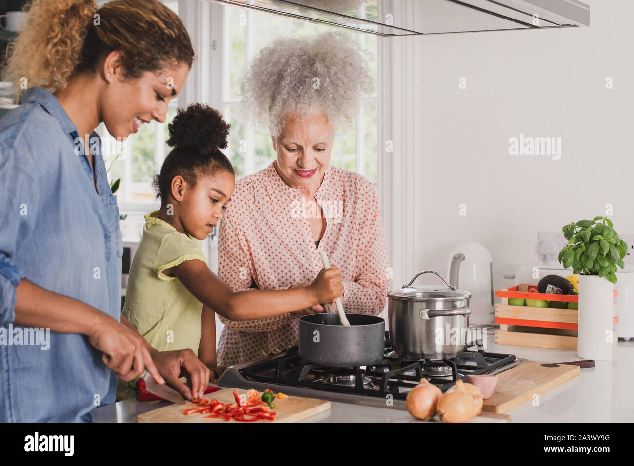 Drei Generationen der Familie Kochen einer Mahlzeit zusammen Stockfoto