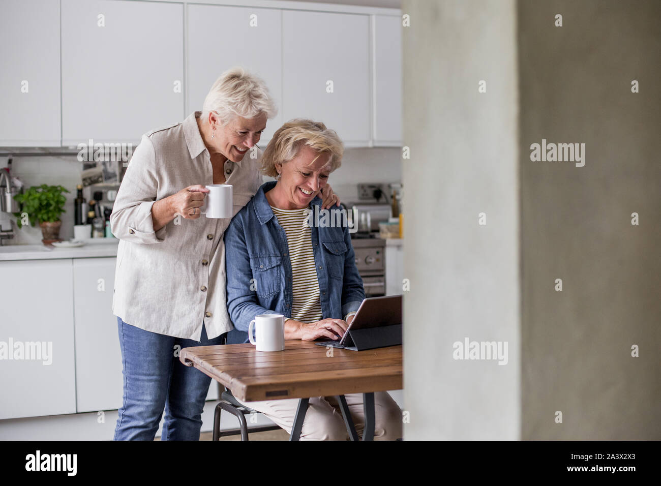 Reifen lesbisches Paar bei digital Tablet zusammen zu Hause suchen Stockfoto