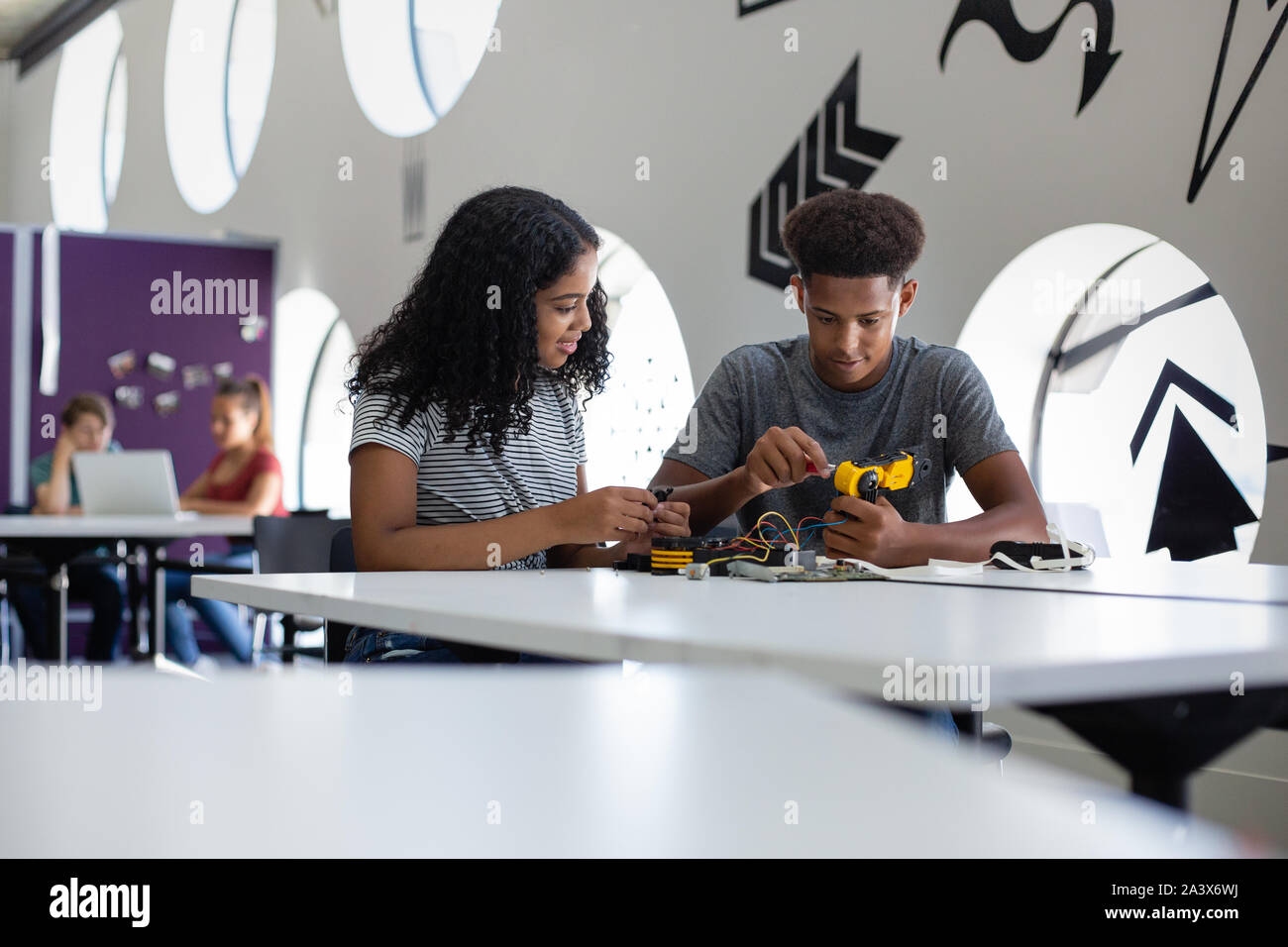 Schülerinnen und Schüler arbeiten an einem Roboterarm in der Klasse Stockfoto