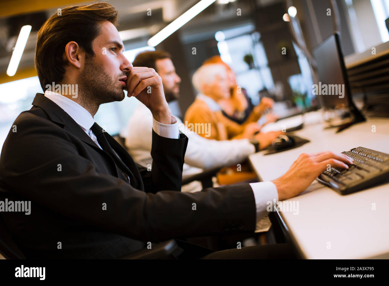 Ansicht des Geschäftsmannes Executive in Gruppe Treffen mit anderen Unternehmern und Unternehmerinnen in modernen Büro mit Computer Stockfoto