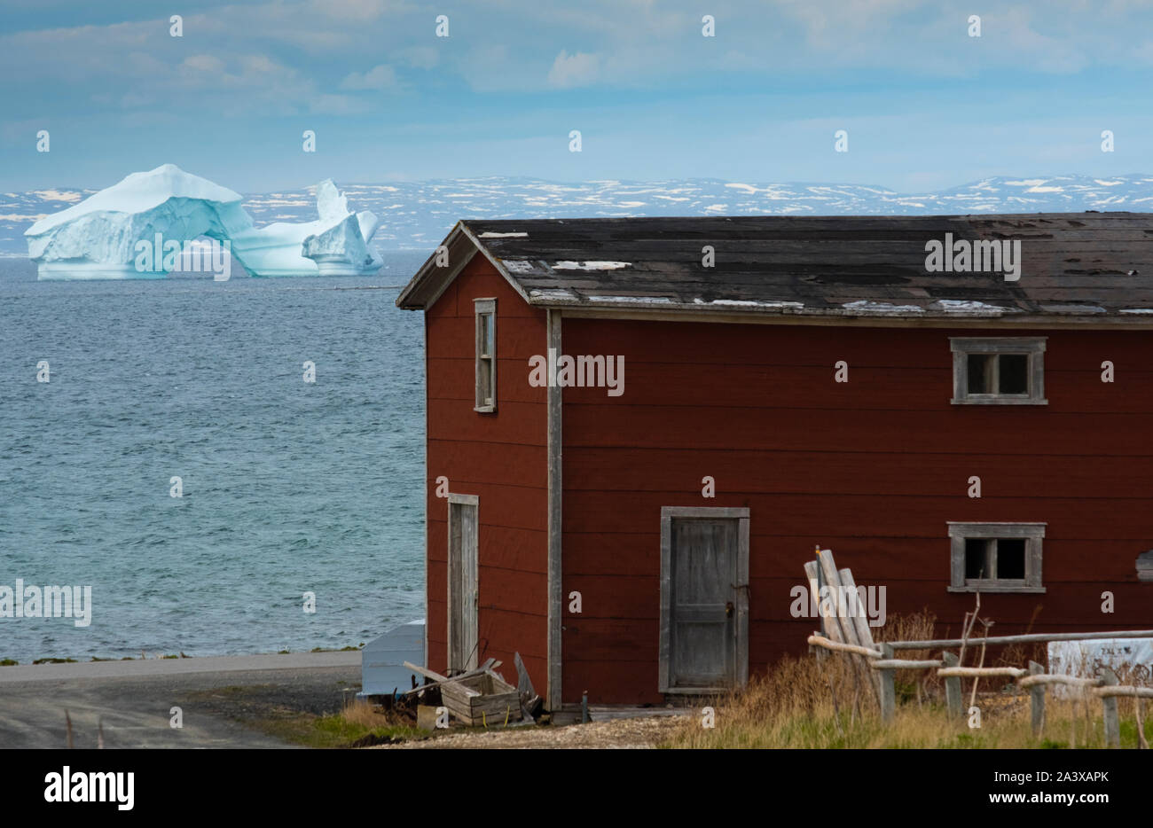 Eisberg auf der Grünen Insel Bucht mit Red Barn im Vordergrund, Neufundland Stockfoto