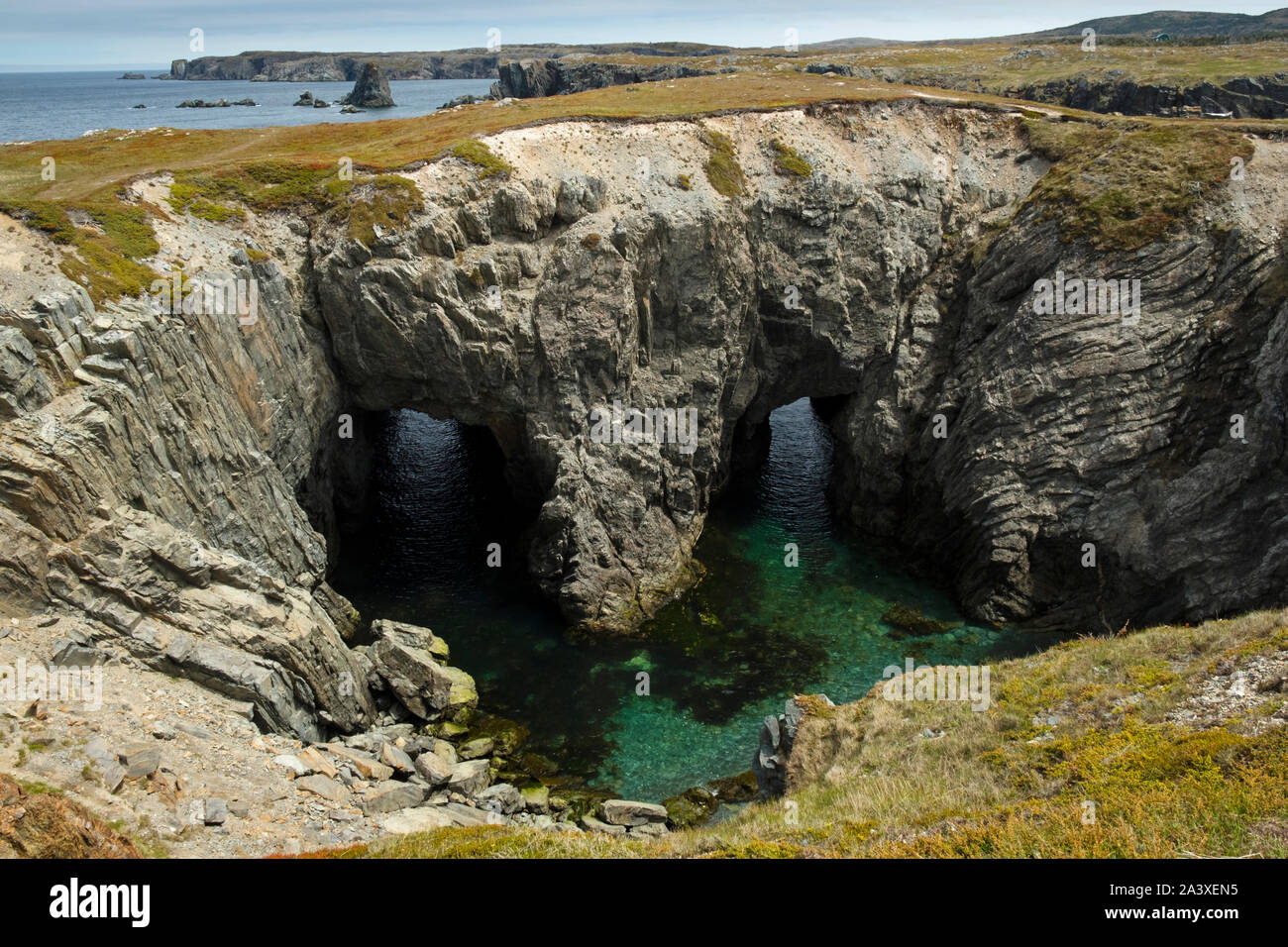 Eine kollabierte Wasserhöhle, die mit einem natürlichen Torbogen in Dungeon Provincial Park, in der Nähe von Canmore, Neufundland, Kanada Stockfoto