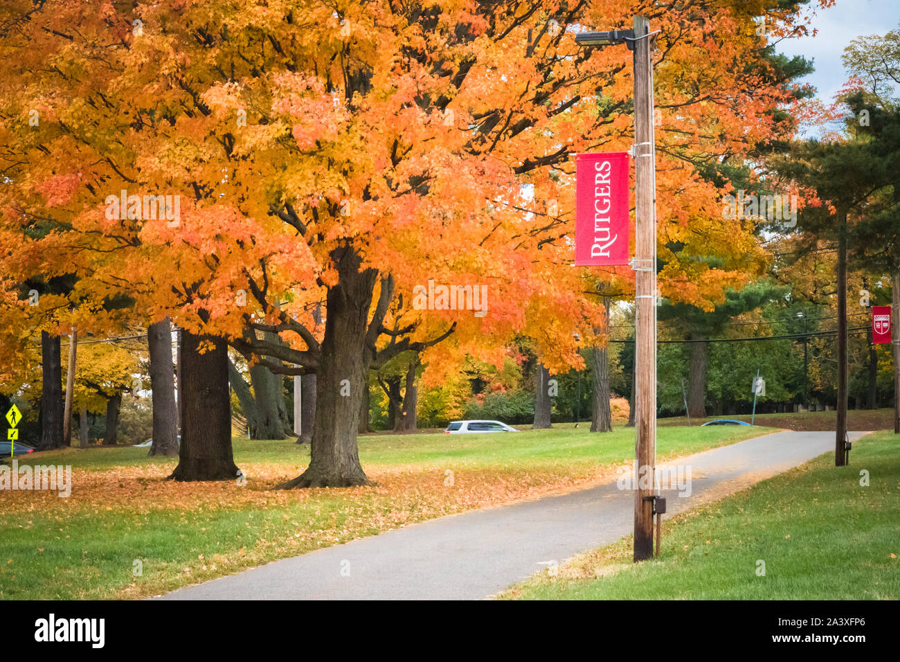 New Brunswick, NJ - 2. November 2018: der Rutgers Universität banner unterzeichnen, mit der gefallenen Ahorn Blätter gold und rot im Herbst. Stockfoto