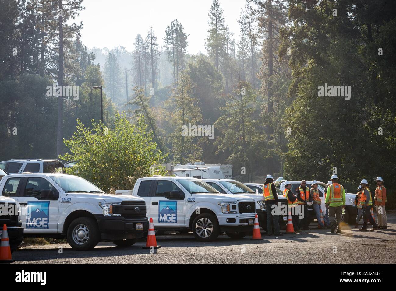 Oktober 10, 2019, Big Oak Flat/Groveland, Kalifornien, USA: Mountain G. Enterprises, Inc. (MGE) Mitarbeiter sammeln für eine Sitzung Donnerstag Morgen im Yosemite gateway Gemeinschaft der großen Eiche Flach/Groveland,] unter diesigen Himmel. Die Briceburg Feuer brennt in der Nähe, und der Rauch hat in der Gemeinschaft. MGE ist ein Notfall vegetation Management Unternehmen von PG&E während der aktuellen Herunterfahren abgeschlossen. Zum Schutz der öffentlichen Sicherheit, PG&E hat den Strom für rund 34.400 Kunden in Tuolumne County wegen böigen Winde und trockene Bedingungen mit erhöhtem Brandrisiko kombiniert. Sobald die weat Stockfoto