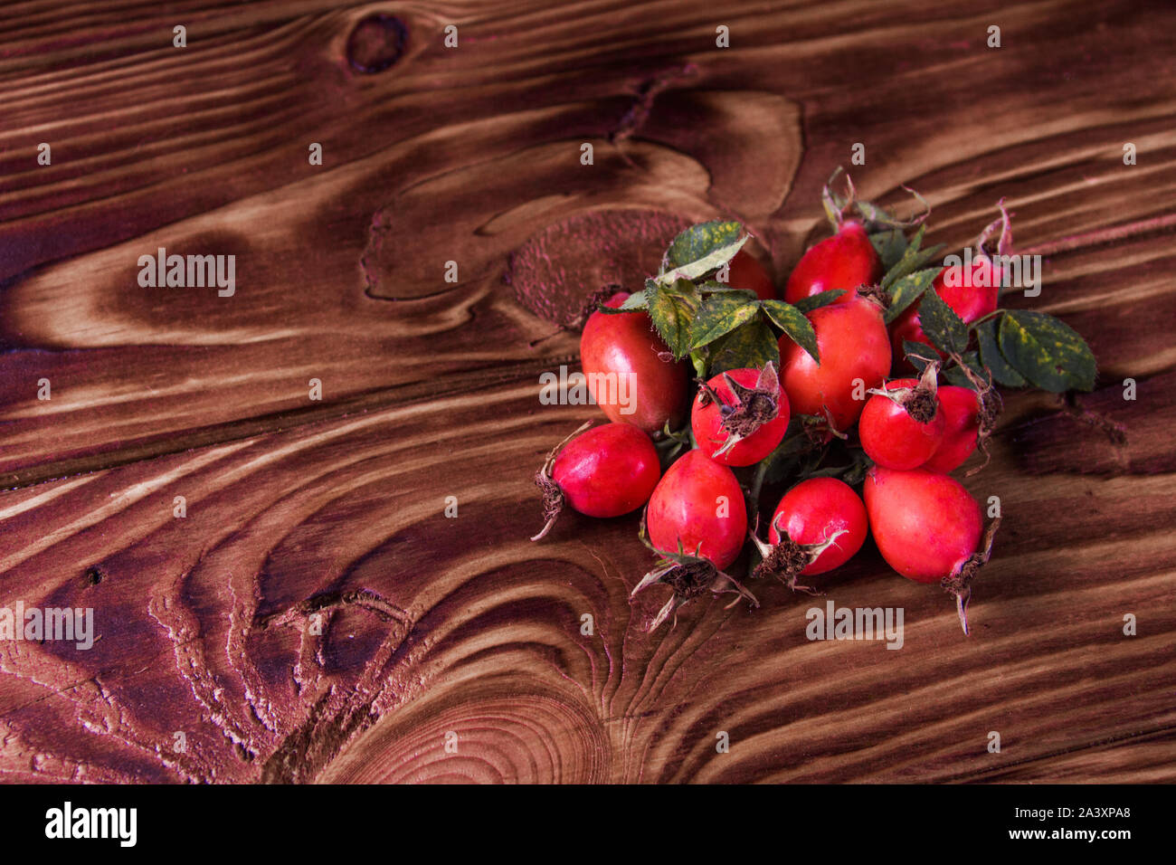 Rose hip auf einer hölzernen Hintergrund Stockfoto