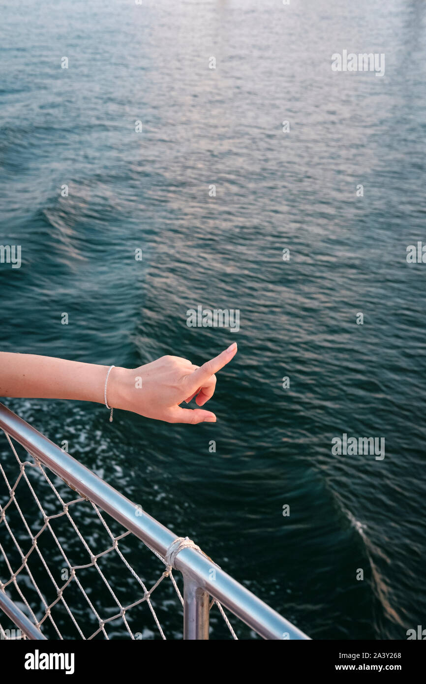 Frau zeigt am Meer Stockfoto