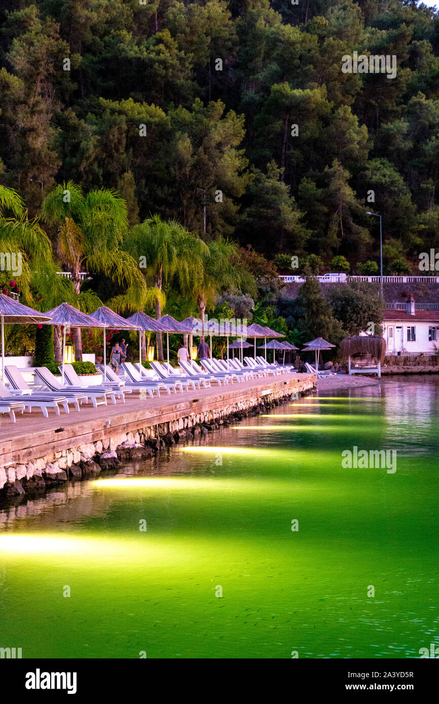 Liegestühle und Sonnenschirme auf der Suche Meer an der Yacht Classic Hotel, Ece Marina Fethiye, Türkische Riviera, Türkei Stockfoto