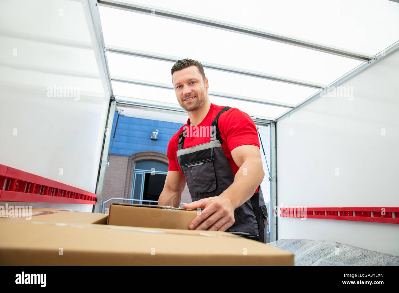 Porträt einer Mover In einheitliche Anordnung der Umzug Kartons innerhalb des Van Stockfoto