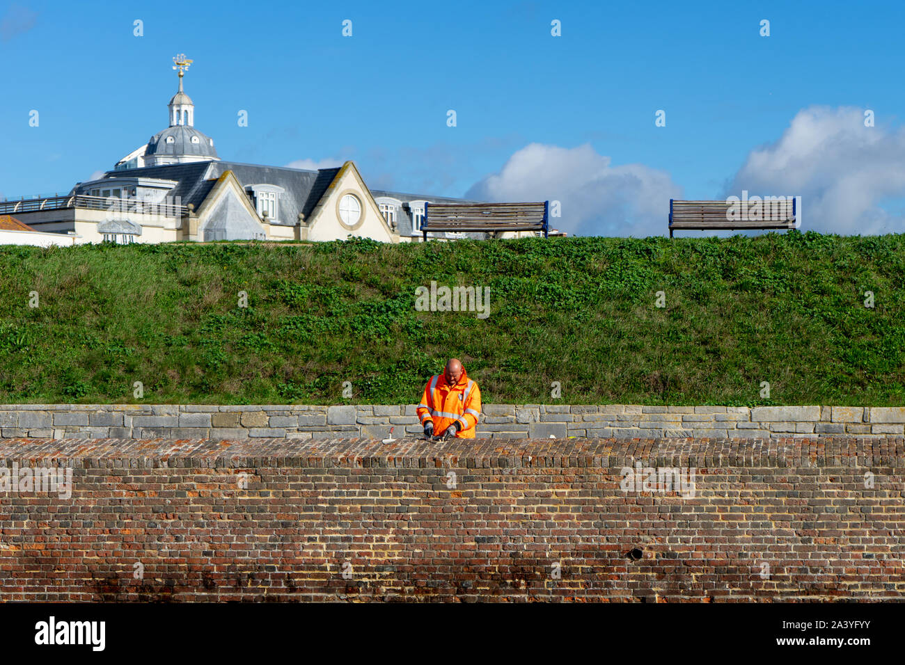 Ein Maurer in Gut sichtbare Kleidung Reparatur einer Mauer Stockfoto