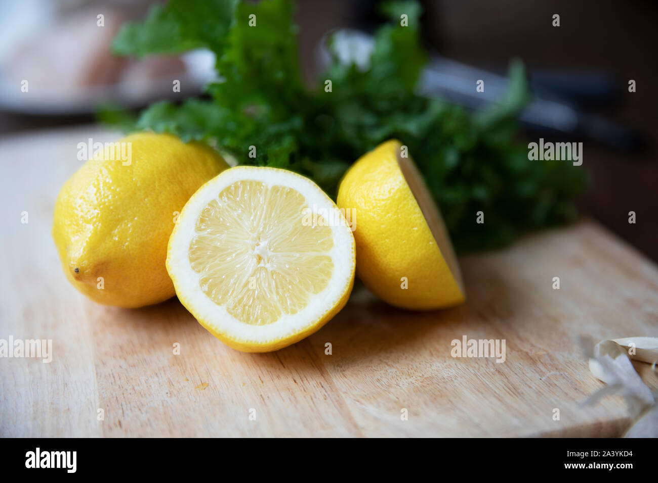 Whollr und halbierte Zitronen auf Schneidebrett Stockfoto