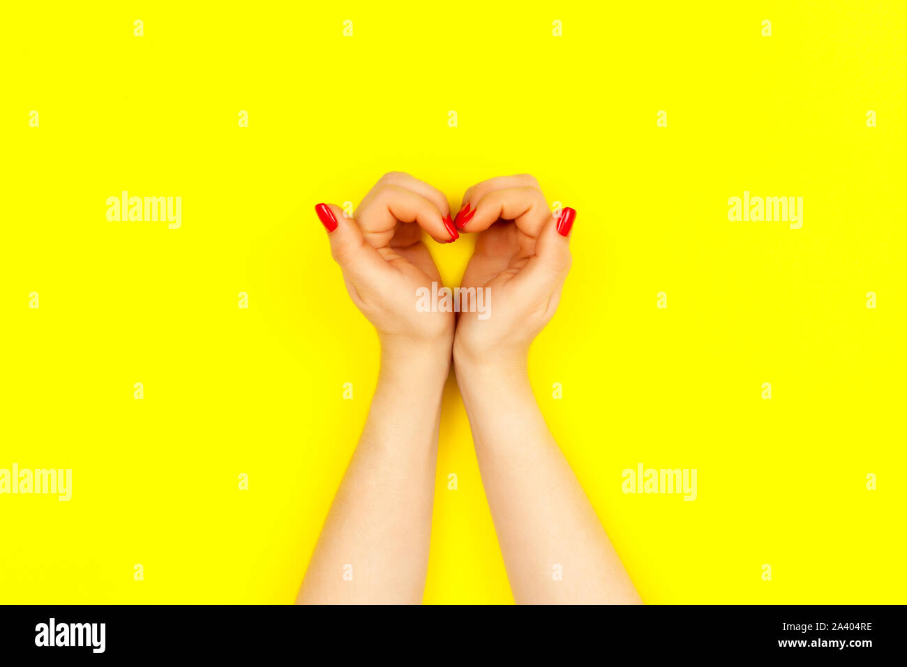 Nägel Design. Zwei schöne Frau mit roten Hände Maniküre aussehen wie Herz auf gelben Hintergrund. Für Text platzieren. Stockfoto