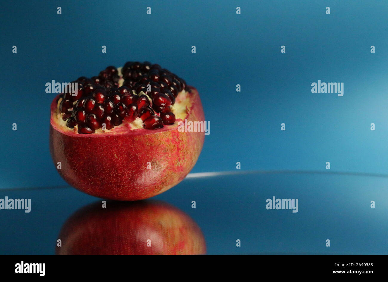 Reife Granatäpfel auf blauem Hintergrund isoliert. Stockfoto
